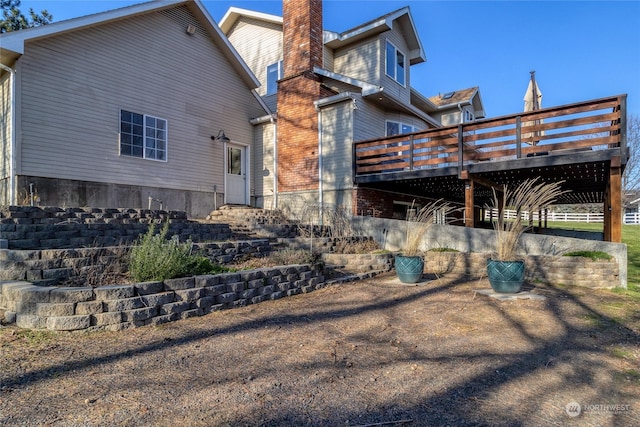 rear view of property featuring a wooden deck