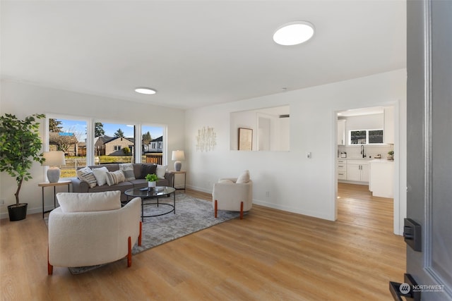 living room with sink and light wood-type flooring