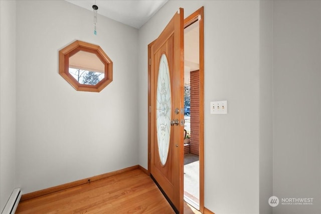 foyer entrance with light wood-type flooring and a baseboard heating unit