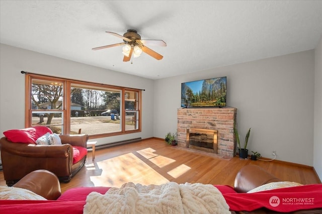 living room with ceiling fan, a fireplace, light hardwood / wood-style floors, and a baseboard heating unit