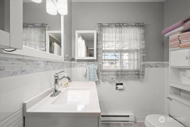 bathroom featuring a baseboard radiator, tile walls, vanity, and toilet