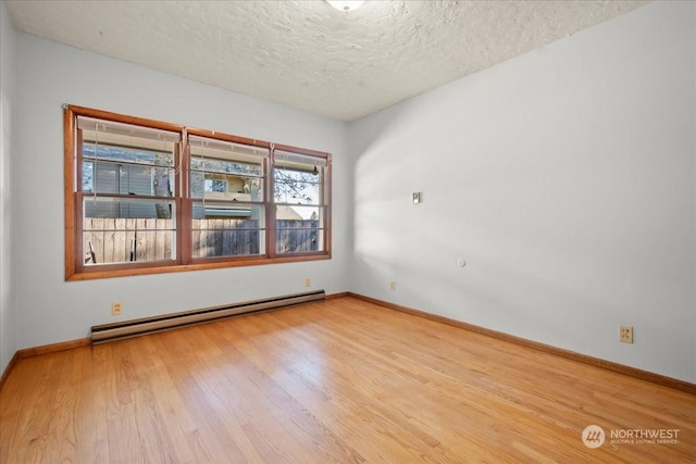 unfurnished room with a textured ceiling, light hardwood / wood-style flooring, and a baseboard heating unit