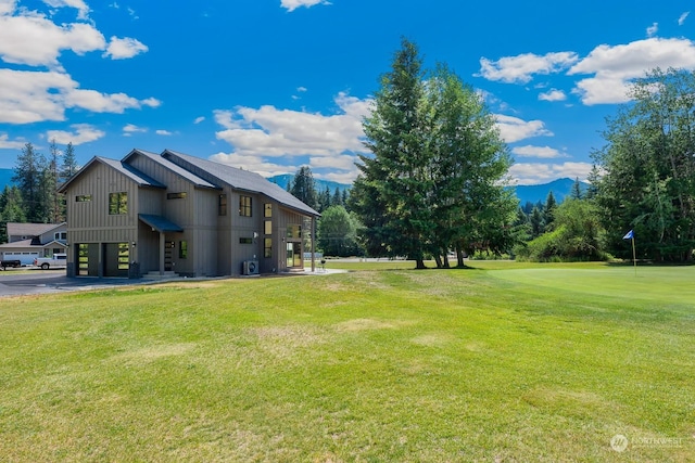 view of yard with a garage, a mountain view, and driveway