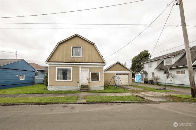 bungalow featuring a garage, an outdoor structure, and a front lawn