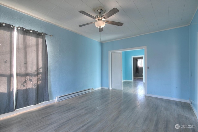 spare room with a baseboard heating unit, crown molding, hardwood / wood-style floors, and ceiling fan