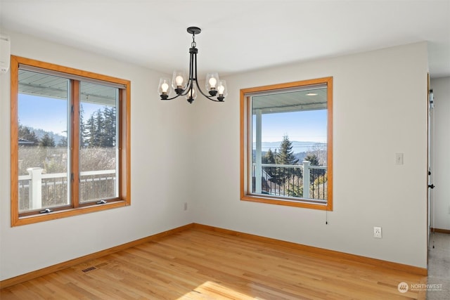 unfurnished room featuring light hardwood / wood-style flooring and a notable chandelier