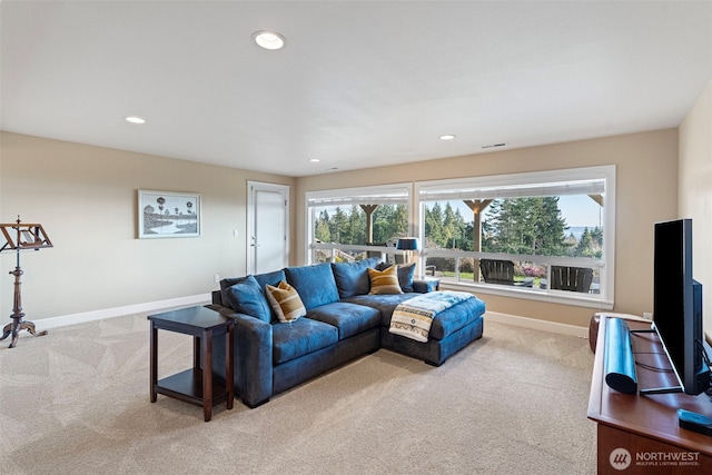 living area featuring light carpet, plenty of natural light, visible vents, and baseboards