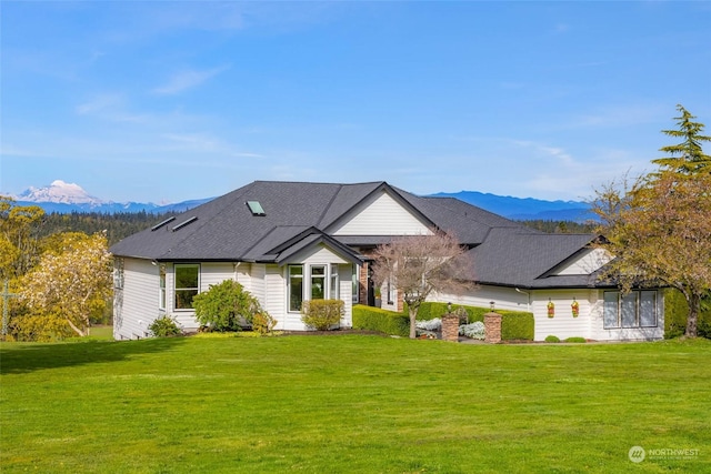 view of front of house with a mountain view and a front yard