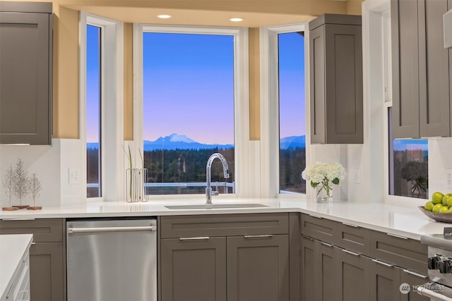 kitchen featuring a mountain view, dishwasher, sink, and gray cabinetry