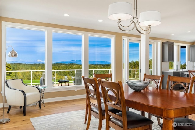 dining space featuring a mountain view, a notable chandelier, and light wood-type flooring