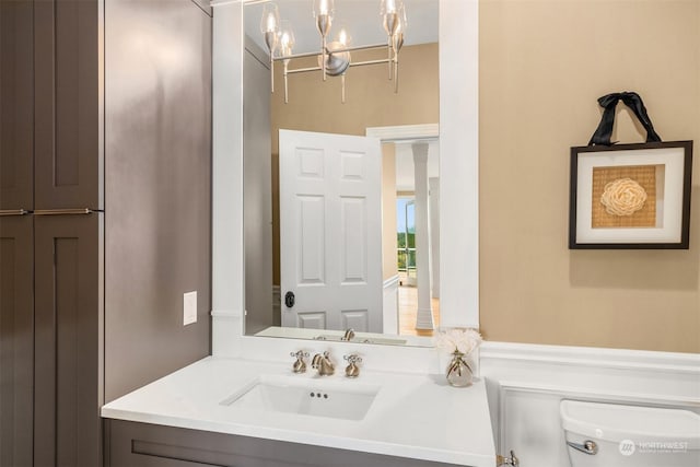 bathroom featuring vanity, a chandelier, and toilet