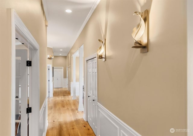 corridor featuring ornamental molding and light wood-type flooring