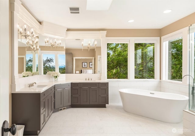 bathroom with vanity, a washtub, and a chandelier