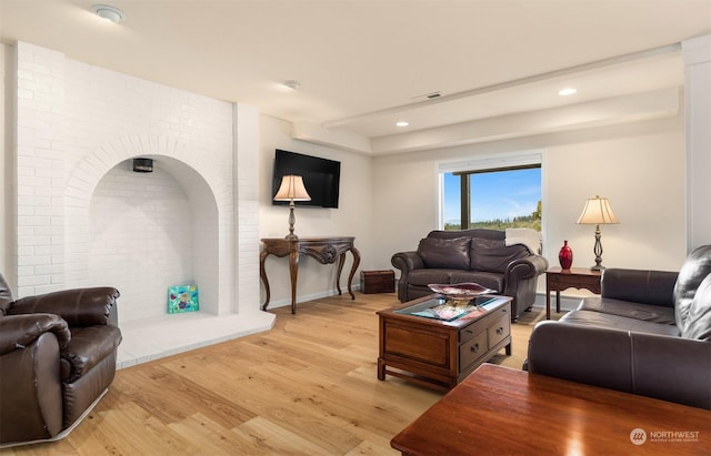 living room featuring brick wall and light wood-type flooring