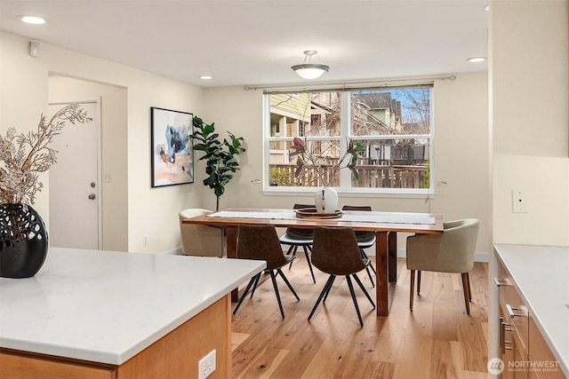 dining space with light wood finished floors and recessed lighting