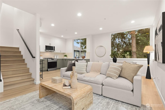 living area with stairs, recessed lighting, and light wood finished floors