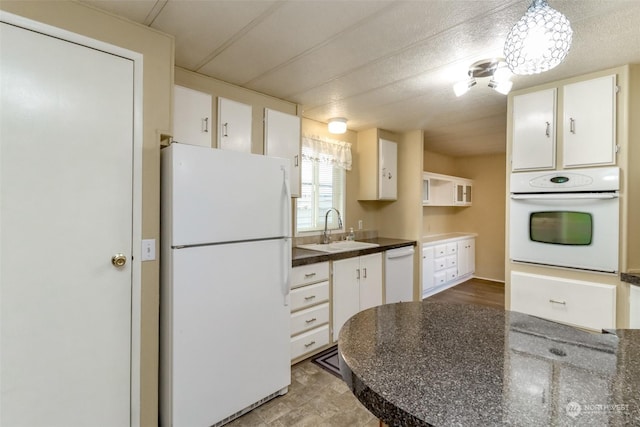 kitchen featuring sink, white cabinets, and white appliances