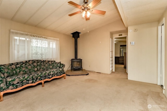 carpeted living room featuring ceiling fan, lofted ceiling, and a wood stove