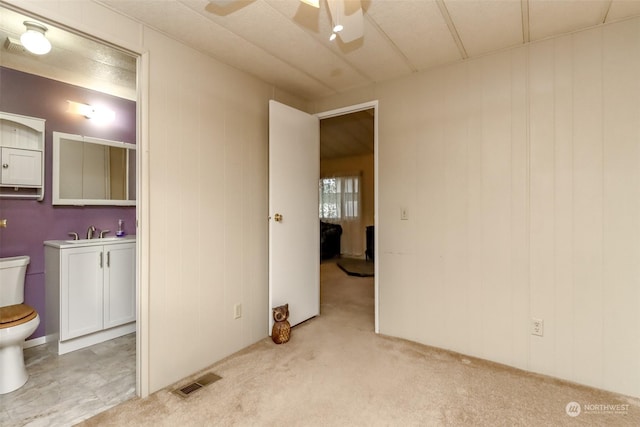 carpeted empty room featuring sink and ceiling fan