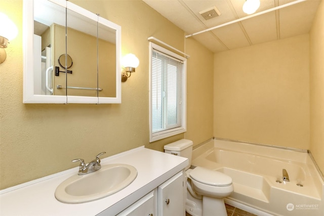 bathroom featuring toilet, vanity, and a bath