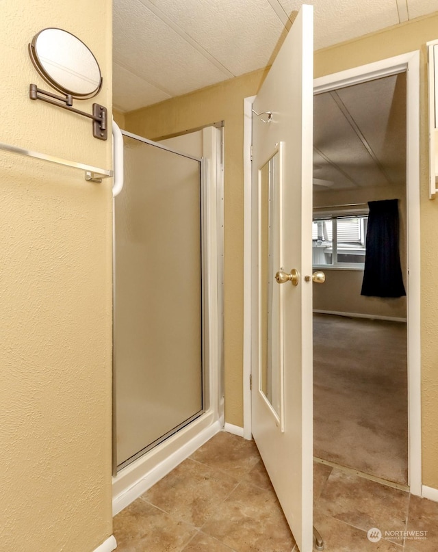 bathroom featuring an enclosed shower and a textured ceiling