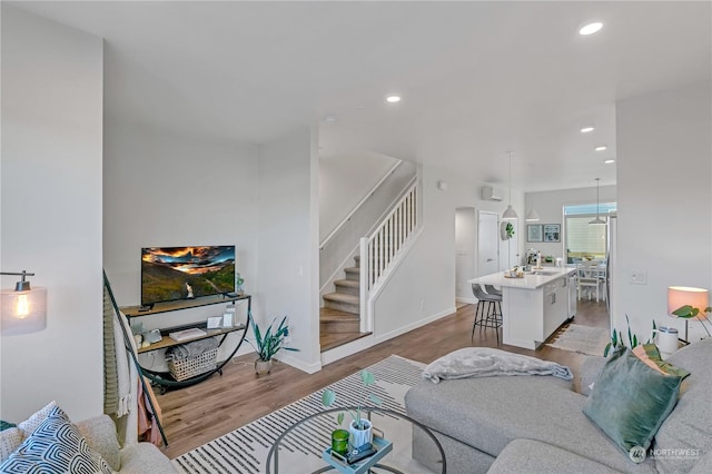 living room featuring sink and light hardwood / wood-style flooring