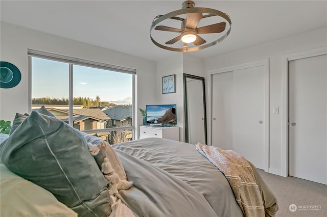 bedroom featuring carpet, two closets, access to exterior, and ceiling fan