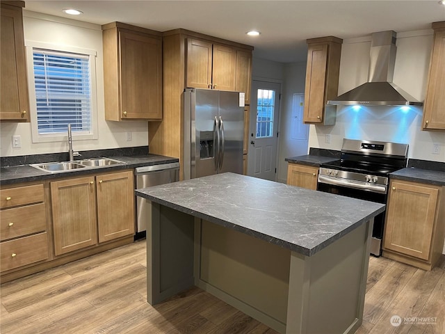 kitchen with sink, a center island, stainless steel appliances, wall chimney range hood, and light hardwood / wood-style flooring