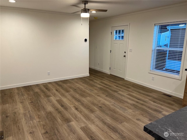 entrance foyer with dark hardwood / wood-style flooring, ornamental molding, and ceiling fan