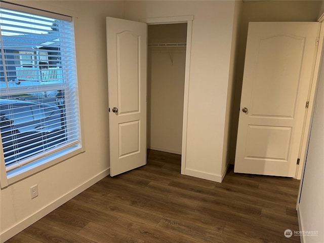 unfurnished bedroom featuring dark hardwood / wood-style floors and a closet