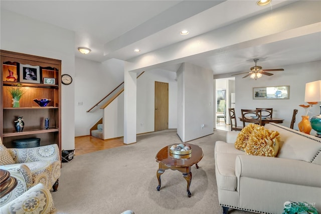 carpeted living room with ceiling fan