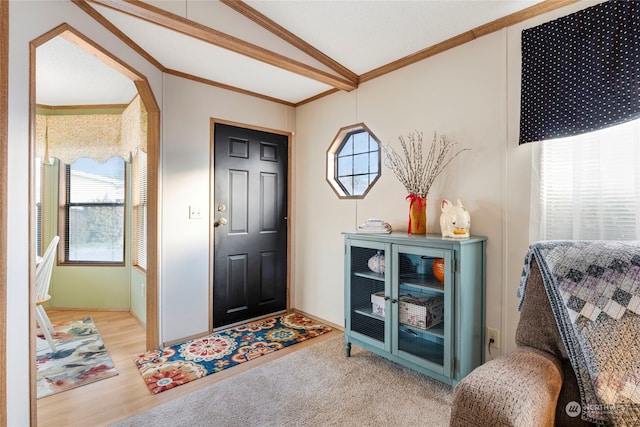 entrance foyer with lofted ceiling, ornamental molding, and hardwood / wood-style floors