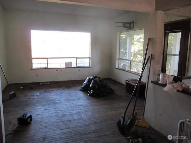 unfurnished room featuring plenty of natural light and dark hardwood / wood-style floors