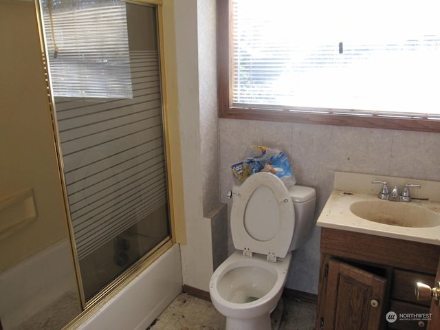 full bathroom with vanity, shower / bath combination with glass door, and toilet