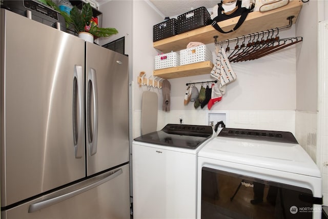 laundry area with separate washer and dryer and a textured ceiling