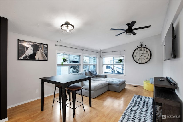 dining area featuring lofted ceiling, ceiling fan, and light wood-type flooring