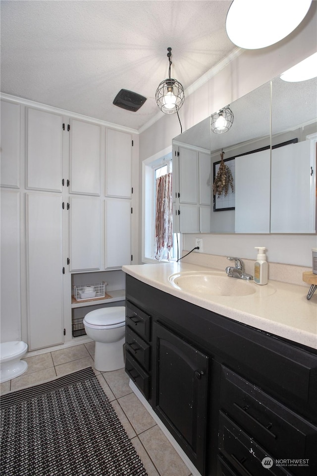 bathroom featuring tile patterned flooring, crown molding, vanity, and toilet