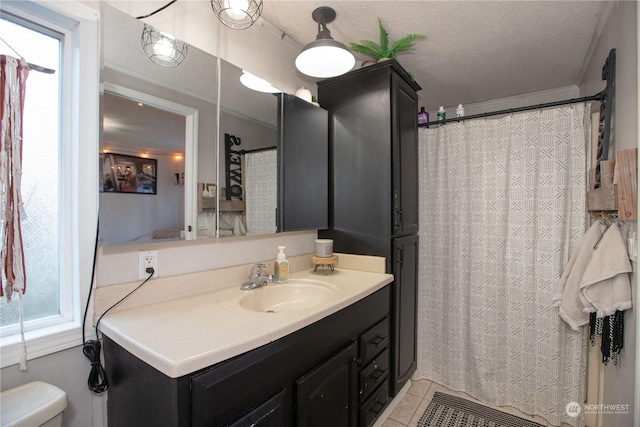 bathroom featuring tile patterned floors, toilet, vanity, and a textured ceiling