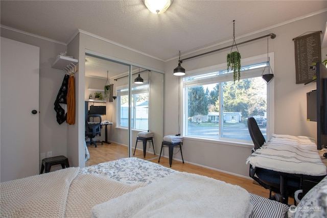 bedroom featuring ornamental molding, light wood-type flooring, and a closet