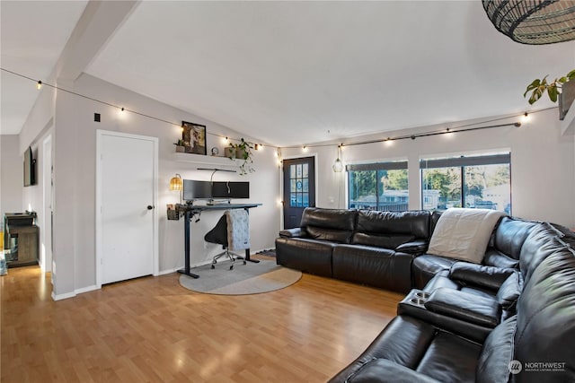 living room featuring lofted ceiling with beams and light wood-type flooring