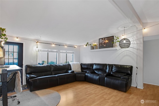 living room featuring light hardwood / wood-style flooring and beamed ceiling