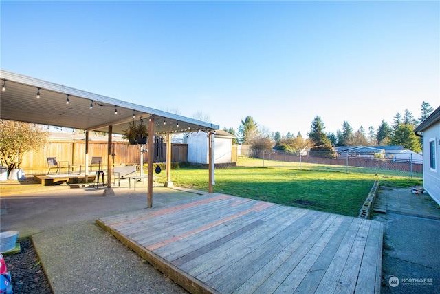 deck with a yard, a patio, and a shed