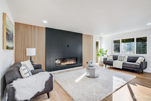 living room featuring light hardwood / wood-style floors and a large fireplace