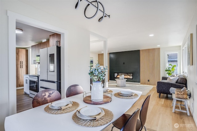 dining area with light hardwood / wood-style flooring and a fireplace