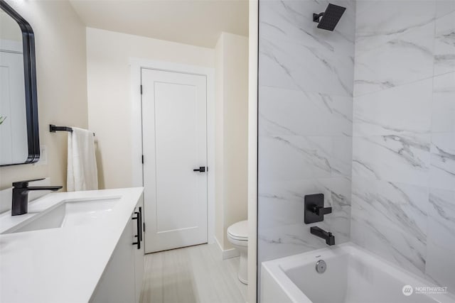 full bathroom with tiled shower / bath combo, vanity, and toilet