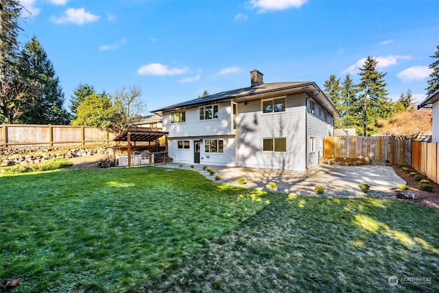 rear view of house featuring a yard and a patio