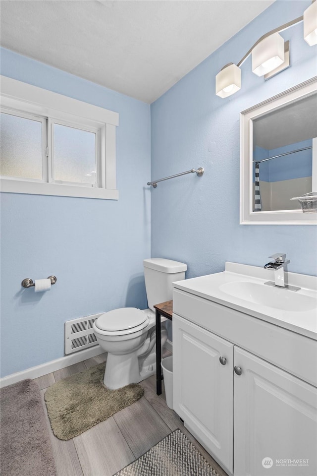 bathroom with vanity, hardwood / wood-style flooring, toilet, and walk in shower