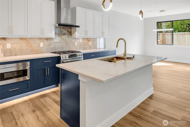 21402 E 39th Dr SE Unit A, Bothell, WA 98021 - kitchen with wall chimney exhaust hood, a sink, blue cabinetry, and light wood finished floors