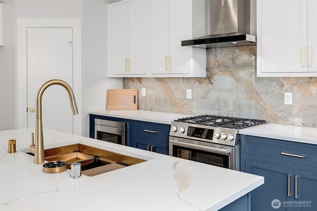21402 E 39th Dr SE Unit A, Bothell, WA 98021 - kitchen with wall chimney range hood, stainless steel range with gas stovetop, blue cabinetry, a sink, and white cabinetry