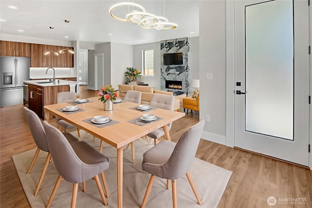 21402 39th Dr SE Unit A, Bothell, WA 98021 - dining space featuring a chandelier, a premium fireplace, light wood-style floors, recessed lighting, and baseboards